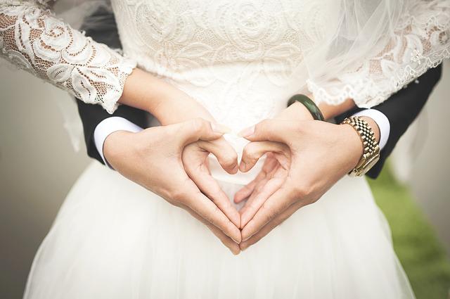 A wedding couple making Heart shape with their hands